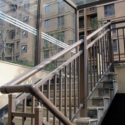 Στον τοίχο τοποθετημένη γυάλινη σκάλα χειροκίνηση με ακροβάθμια από ανοξείδωτο χάλυβα και σύγχρονη εμφάνιση σχεδιασμού